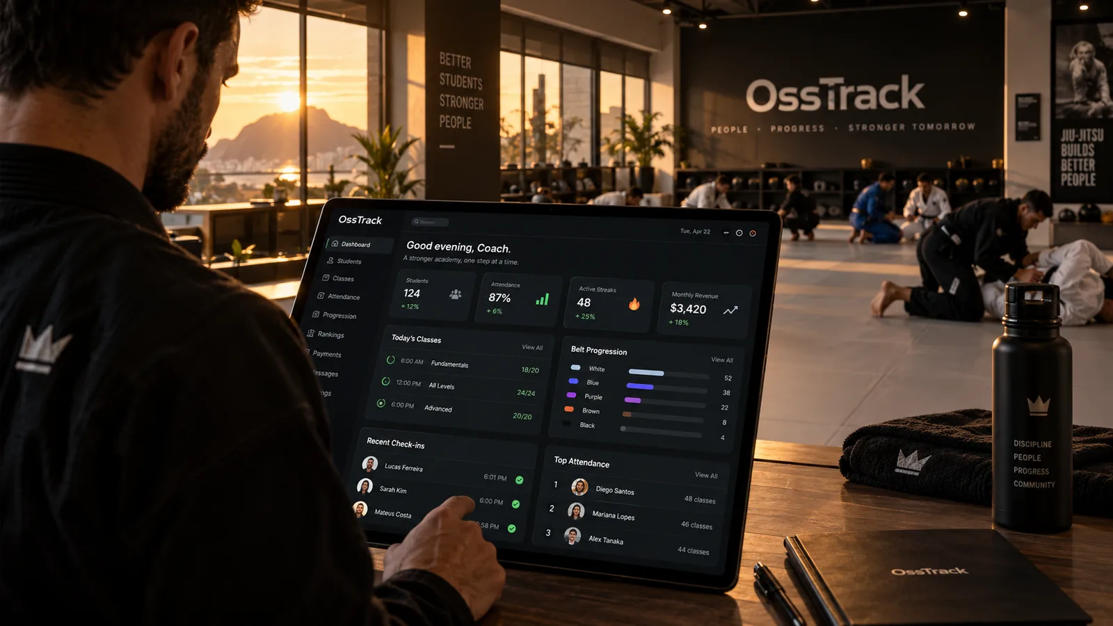Treino rolando no tatame enquanto o OssTrack gerencia a academia no computador